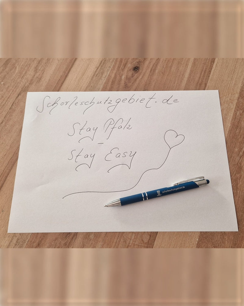 Der Kugelschreiber auf einem Zettel mit handgeschriebenem Stay Pfalz – Stay Easy